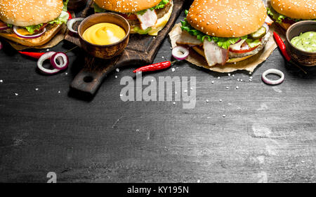 Fast food. Varie hamburger con salse. Sulla lavagna. Foto Stock