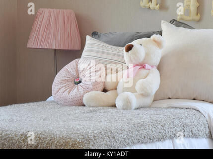 Moderna camera per bambini con bambola e cuscini sul letto Foto Stock