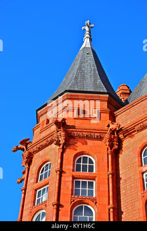 Doccioni esotici (o) chimera si trova vicino alla parte superiore di mattoni rossi iconico Edificio Pierhead nella Baia di Cardiff. Un grado che ho elencato la costruzione. Foto Stock