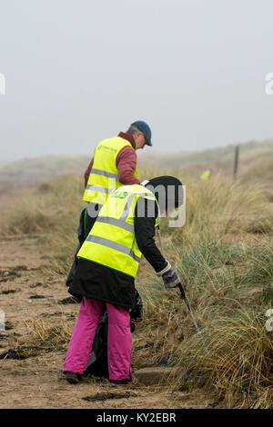 Aindsdale, Southport. Dodicesimo Dicembre, 2018. Regno Unito Meteo. Nebbioso giorno per la spiaggia pulita volontari e comunità ulteriori aiutanti clean up dopo le recenti tempeste che hanno lasciato dietro di sé le bevande tazze, posate, cannucce, le bottiglie di plastica, coperchi agitatori, benne, politene, monouso, articoli usa e getta, stringa, corda, accendini, sostanze chimiche artificiali e detriti di lettiera in strandline. Tempesta Eleanor ha lasciato spiagge disseminate di oggetti sgottate dai fondali dalle onde descritto come un onda di marea di rifiuti e di rimozione è enorme. Credito: MediaWorldImages/Alamy Live News Foto Stock