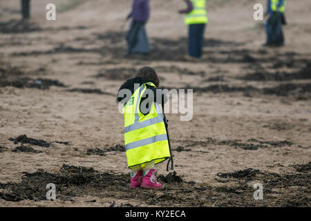 Aindsdale, Southport. Dodicesimo Dicembre, 2018. Regno Unito Meteo. Nebbioso giorno per la spiaggia pulita volontario di 4 anni, Molly Flower-Steel (MR) e trenta altri aiutanti clean up dopo le recenti tempeste hanno lasciato dietro di sé le bevande tazze, posate, cannucce, le bottiglie di plastica, coperchi agitatori, benne, politene, monouso, articoli usa e getta, stringa, corda, accendini, sostanze chimiche artificiali e detriti di lettiera in strandline. Tempesta Eleanor ha lasciato spiagge disseminate di oggetti sgottate dai fondali dalle onde descritto come un onda di marea di rifiuti e di rimozione è enorme. Credito: MediaWorldImages/Alamy Live News Foto Stock