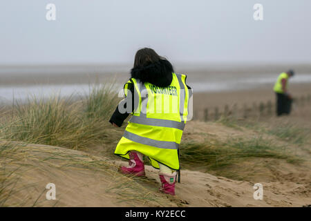 Aindsdale, Southport. Dodicesimo Dicembre, 2018. Regno Unito Meteo. Nebbioso giorno per la spiaggia pulita volontari e comunità ulteriori aiutanti clean up dopo le recenti tempeste che hanno lasciato dietro di sé le bevande tazze, posate, cannucce, le bottiglie di plastica, coperchi agitatori, benne, politene, monouso, articoli usa e getta, stringa, corda, accendini, sostanze chimiche artificiali e detriti di lettiera in strandline. Tempesta Eleanor ha lasciato spiagge disseminate di oggetti sgottate dai fondali dalle onde descritto come un onda di marea di rifiuti e di rimozione è enorme. Credito: MediaWorldImages/Alamy Live News Foto Stock