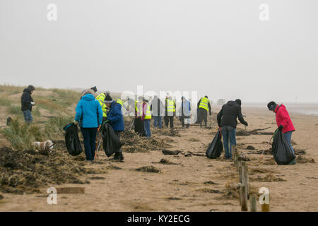 Aindsdale, Southport. Dodicesimo Dicembre, 2018. Regno Unito Meteo. Nebbioso giorno per la spiaggia pulita volontari e comunità ulteriori aiutanti clean up dopo le recenti tempeste che hanno lasciato dietro di sé le bevande tazze, posate, cannucce, le bottiglie di plastica, coperchi agitatori, benne, politene, monouso, articoli usa e getta, stringa, corda, accendini, sostanze chimiche artificiali e detriti di lettiera in strandline. Tempesta Eleanor ha lasciato spiagge disseminate di oggetti sgottate dai fondali dalle onde descritto come un onda di marea di rifiuti e di rimozione è enorme. Credito: MediaWorldImages/Alamy Live News Foto Stock