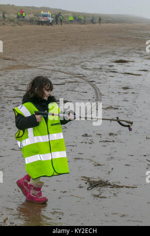 Aindsdale, Southport. Dodicesimo Dicembre, 2018. Regno Unito Meteo. Nebbioso giorno per la spiaggia pulita volontario di 4 anni, Molly Flower-Steel (MR) e trenta altri aiutanti clean up dopo le recenti tempeste hanno lasciato dietro di sé le bevande tazze, posate, cannucce, le bottiglie di plastica, coperchi agitatori, benne, politene, monouso, articoli usa e getta, stringa, corda, accendini, sostanze chimiche artificiali, spiaggia cucciolata detriti nel strandline. Tempesta Eleanor ha lasciato spiagge disseminate di oggetti sgottate dai fondali dalle onde descritto come un onda di marea di rifiuti e di rimozione è enorme. Credito: MediaWorldImages/Alamy Live News Foto Stock