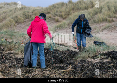 Aindsdale, Southport. Dodicesimo Dicembre, 2018. Regno Unito Meteo. Nebbioso giorno per la spiaggia pulita volontari e comunità ulteriori aiutanti clean up dopo le recenti tempeste che hanno lasciato dietro di sé le bevande tazze, posate, cannucce, le bottiglie di plastica, coperchi agitatori, benne, politene, monouso, articoli usa e getta, stringa, corda, accendini, sostanze chimiche artificiali e detriti di lettiera in strandline. Tempesta Eleanor ha lasciato spiagge disseminate di oggetti sgottate dai fondali dalle onde descritto come un onda di marea di rifiuti e di rimozione è enorme. Credito: MediaWorldImages/Alamy Live News Foto Stock