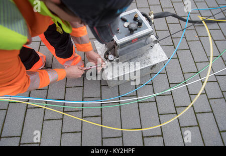 Uno specialista per l'installazione della fibra ottica dimostra come un cavo in fibra ottica è spinto in un condotto vuoto con l aiuto di un dispositivo di inserimento durante l'evento di chiusura del progetto 'internet ad alta velocità nel quartiere Neckar-Odenwald' in Buchen, Germania, 12 gennaio 2018. Foto: Marijan Murat/dpa Foto Stock