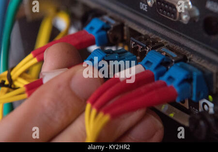 Uno specialista per l'installazione della fibra ottica dimostra come un cavo a fibra ottica viene inserita in un router durante l'evento di chiusura del progetto 'internet ad alta velocità nel quartiere Neckar-Odenwald' in Buchen, Germania, 12 gennaio 2018. Foto: Marijan Murat/dpa Foto Stock