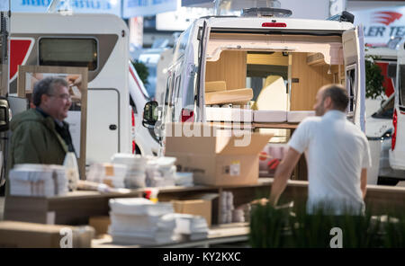 Stuttgart, Germania. Xii gen, 2018. Fair i dipendenti in una conversazione di fronte roulotte un giorno prima dell'apertura della fiera viaggio 'Caravan Motor Touristik" a Stoccarda, Germania, 12 gennaio 2018. Circa 2000 espositori, come ad esempio i produttori di caravan e tour operator, sarà la presentazione di nuovi prodotti e servizi tra il 13 e il 21 gennaio 2018. Credito: Sebastian Gollnow/dpa/Alamy Live News Foto Stock