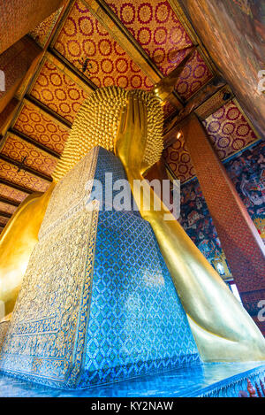 Vista dal retro del gold Buddha sdraiato in un tempio a Bangkok Foto Stock