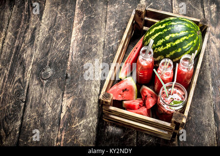 Cocktail di freschi Cocomeri di bottiglie. Su uno sfondo di legno. Foto Stock