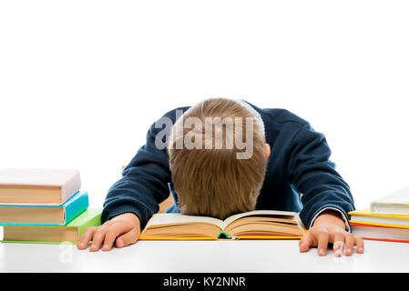 Uno scolaro a una tabella in una tabella si è addormentato mentre la lettura, riprese in studio Foto Stock