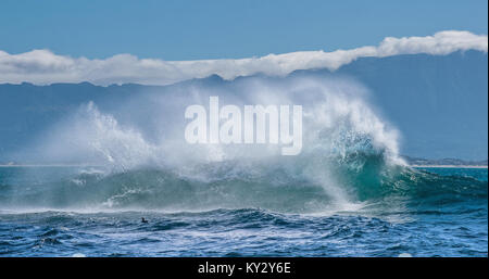 Paesaggio marino. Le nuvole del cielo, onde con schizzi, montagne sagome. False Bay. Sud Africa. Foto Stock