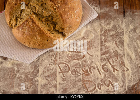 Traditional Irish Soda Pane per il giorno di San Patrizio è servita su infarinato e tavolo in legno Foto Stock