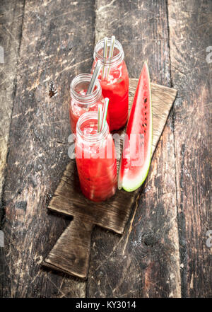 Cocktail di freschi Cocomeri di bottiglie. Su uno sfondo di legno. Foto Stock