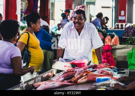 Pescatore africano vendere il suo pesce del mercato proprie di una donna, Seicelle Foto Stock