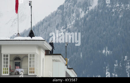 Ufficio federale di polizia sono cecchini custodendo le strade di Davos dal tetto del grand hotel Belvedere di Davos, in Svizzera, durante il Forum Economico Mondiale (WEF) il 25 gennaio 2013. Ogni anno, massiccia precauzioni di sicurezza per il WEF girare la Svizzera piccolo villaggio alpino di Davos in una fortezza. Foto Stock