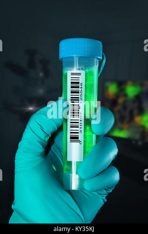 La mano guantata detiene con un codice a barre campione liquido nella camera per microscopia Foto Stock