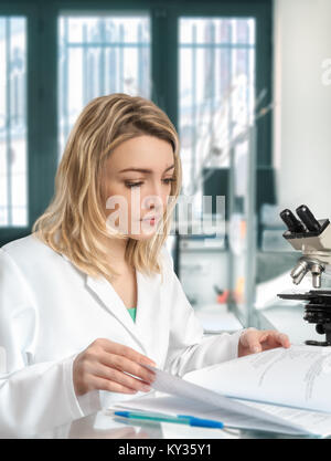 Giovani donne scienziato in laboratorio controlli il laboratorio ufficiale Foto Stock