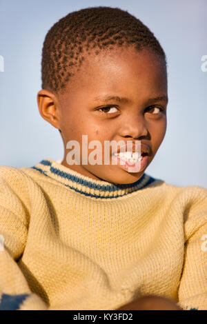 Motswana bambino sorridente contro lo sfondo del cielo Foto Stock