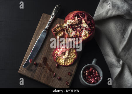 Il Melograno e semi appena aperto sul tavolo in legno Foto Stock