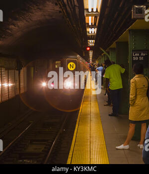 New York, nello Stato di New York, Stati Uniti d'America. In treno arrivando a Lexington Avenue di New York City metropolitana stazione. Foto Stock