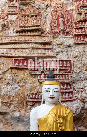 Vecchio tempio con statue di Buddha e sculture religiose sulla roccia calcarea nella sacra Kaw Goon grotta vicino Hpa-An in Myanmar (Birmania) Foto Stock