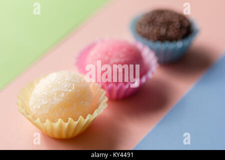 Caramelle brasiliano: Brigadeiro, Beijinho e Bicho de Pe. Bambini festa di compleanno. Candy palle in linea retta. Sfondo colorato. Foto Stock