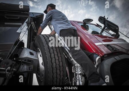 Driver caucasica nel suo 30s prepara il suo semi carrello per il prossimo viaggio commerciale. Foto Stock