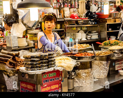 Fornitore di donna che serve i clienti al mercato Gwangjang in Seoul. Uno dei più popolari street food luogo dove è possibile acquistare kimbap, bibimbap, kimchi. Foto Stock