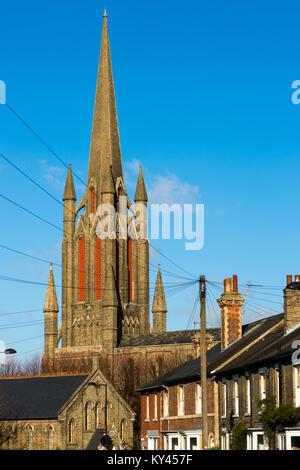 Tra i filari di bianco e rosso mattone case terrazza è William Rangers 1840 Victorian chiesa gotica di San Giovanni Evangelista. Bury St Edmunds, Suffolk Foto Stock