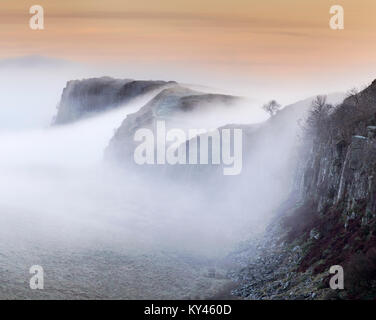 Il Vallo di Adriano: la vista da acciaio Rigg in una nebbiosa Winter's mattina all'alba, guardando ad est verso la falesia di Lough, sbucciare, Highshield Hotbank e falesie. Foto Stock