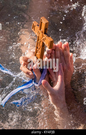 Salonicco, 6 Gennaio 2018: una inquadratura ravvicinata delle mani che recupera una croce di legno nel mare, presso la benedizione dell acqua cerimonia th Foto Stock