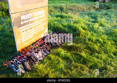 Sussex, Regno Unito. Scarpe abbandonate giacciono sull'erba dopo una dura Mudder evento. Foto Stock