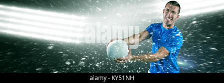 Immagine composita del ritratto di sorridere giocatore di rugby in maglia blu sfera di trattenimento Foto Stock