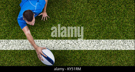 Immagine composita della vista posteriore del giocatore di rugby che giace di fronte con sfera Foto Stock