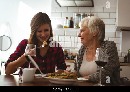 Donna Senior e la figlia di mangiare la frittata e vino Foto Stock