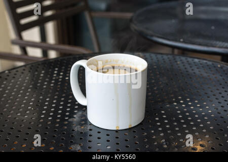 Caffè Americano in bianco standard mug su nero tavolo in metallo con caffè corre Foto Stock