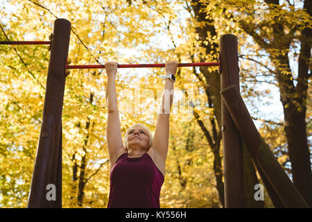 Senior donna pratica di esercizio nel parco Foto Stock