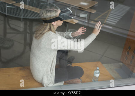 Ragazza adolescente utilizzando la realtà virtuale auricolare Foto Stock