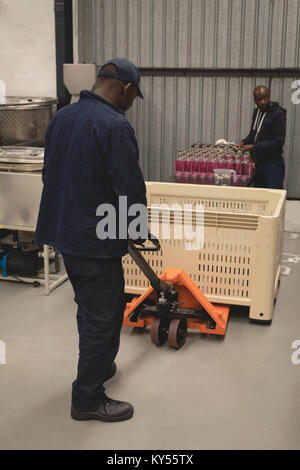 I lavoratori di carico bottiglie di gin nel martinetto pallet Foto Stock