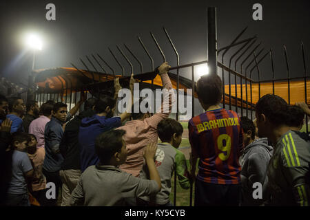 Ottobre 28, 2017 - Damasco, Siria - i ragazzi e gli uomini peer attraverso il bar che circondano il passo durante il siriano il calcio finale di Coppa Tishreen Stadium..il calcio siriano cup finale è stata giocata tra Al-Wahda Al-Karamah e squadre di calcio..Nonostante il conflitto in corso in un paese lacerato dalla guerra di Siria, il calcio siriano cup finale è stata ospitata nella città capitale di Damasco che è sotto il governo siriano di controllo con molti locali per gli appassionati di calcio hanno assistito alla partita. (Credito Immagine: © Sally Hayden/SOPA via ZUMA filo) Foto Stock