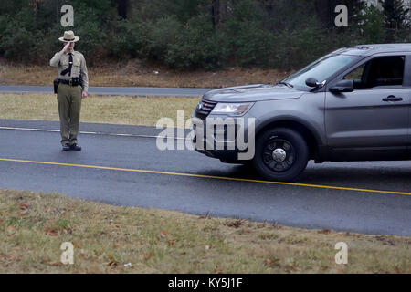 Un Maryland membro Trooper saluta come presidente degli Stati Uniti Trump di teste per il giro della Papamobile a Walter Reed Militare Nazionale Medical Center per il suo annuale esame fisico 12 gennaio 2018 di Bethesda, Maryland. Trump al prossimo viaggio in Florida per trascorrere il Dr Martin Luther King Jr day weekend di vacanza al suo Mar-a-Lago resort. Credit: Chip Somodevilla/Piscina via CNP - nessun filo SERVICE - foto: Chip Somodevilla/piscina attraverso consolidati/dpa Foto Stock