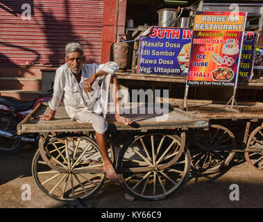 Indian uomo seduto su un carrello, Pushkar, Rajasthan, India Foto Stock