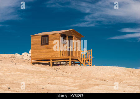 Piccolo bagno in legno casa su di una spiaggia di sabbia bianca. Foto Stock