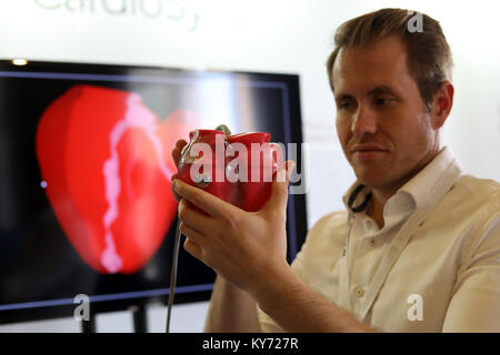 Uomo con modello di plastica di un cuore umano Foto Stock