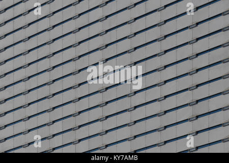 Immagine di sfondo di una facciata di un edificio per uffici con piccole finestre. Foto Stock