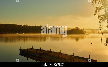 Misty vista alla luce del sole sopra il lago all'alba, Ljustero, contea di Stoccolma, Svezia, in Scandinavia. Foto Stock