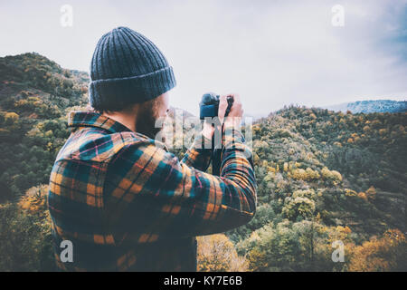 Fotografo uomo prendendo foto di montagne Travel Lifestyle adventure concept vacanze attive nel selvaggio indossando accogliente plaid shirt e hat Foto Stock