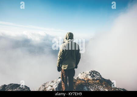 Traveler uomo sul vertice di montagna da soli godendo veduta aerea nuvole stile di vita viaggio concetto di successo avventura vacanze attive outdoor vista posteriore Foto Stock