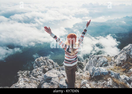 Donna felice traveler sul vertice di montagna le mani sollevate oltre le nuvole stile di vita viaggio concetto di successo avventura vacanze attive outdoor armonia con natu Foto Stock